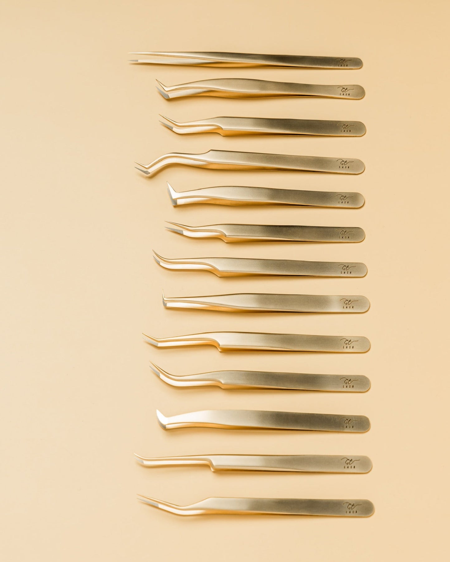 Flatlay of GT Lash Co’s full fiber tip tweezer collection, including isolation and volume fan tweezers designed for professional lash artists. Perfect for building a complete lash extension toolkit.