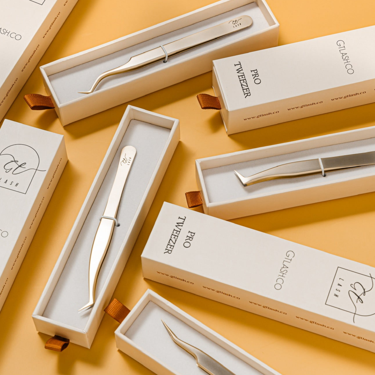 GT Lash Co packaging display for professional lash tweezers, featuring gold fiber tip tweezers in white branded boxes — ideal for lash artists who value premium lash extension tools and organized kits.